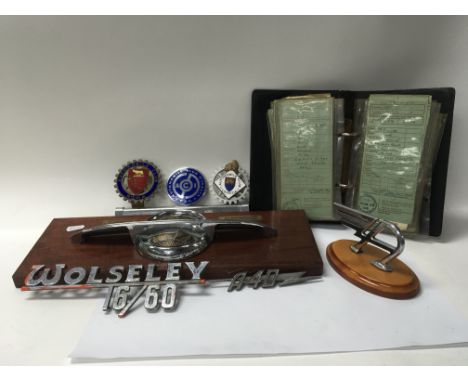 A collection of various car badges including Automobile a Club Italia and car registration books, mostly Fords and Bedford re