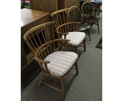 Two Ercol Windsor stickback chairs plus two other light wood carvers of similar type