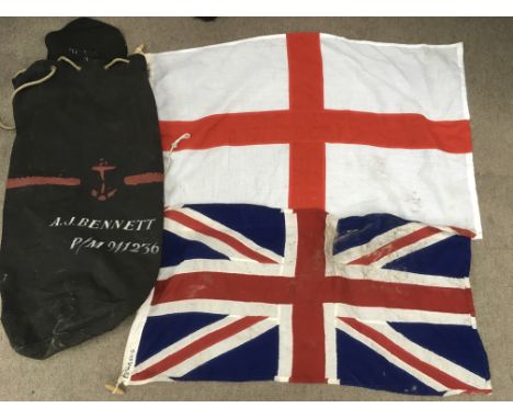A vintage kit bag containing three large ship's flags plus two smaller flags.