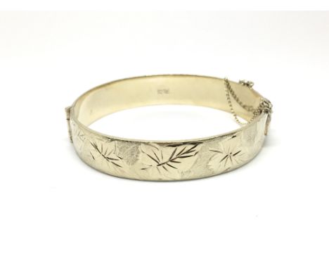 A silver bangle decorated with leaves, hallmarked for Birmingham 1971, maker Excalibur Jewellery Limited. Total weight approx