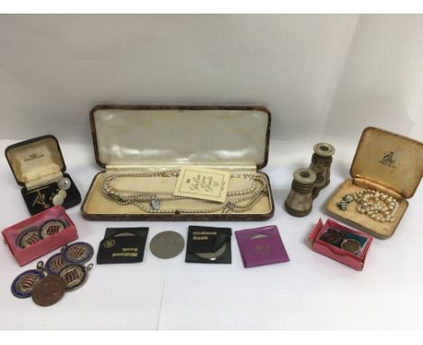 A collection of oddments comprising pearl necklaces, coins, opera glasses, medals etc.
