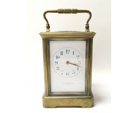A brass cased carriage clock striking on a gong, maker Gowland Brothers of Paris. The white dial presenting blue Arabic numer