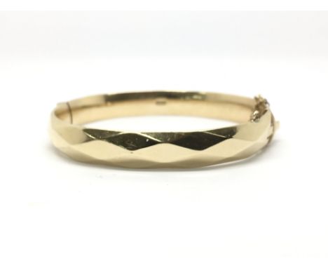 A gold plated bangle, marked M H M.