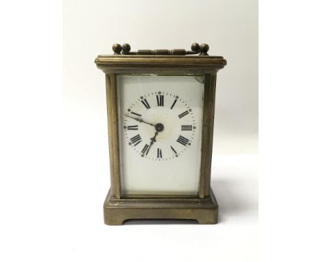 A small brass cased carriage clock with Roman numerals.