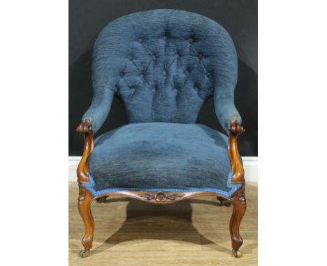A Victorian club armchair, button back, stuffed-over upholstery, scroll carved handrests, serpentine seat, French cabriole fo