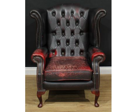 A 'Chesterfield' office reception wingback armchair, deep-button back, squab cushion, 102cm high, 91cm wide, the seat 46cm wi
