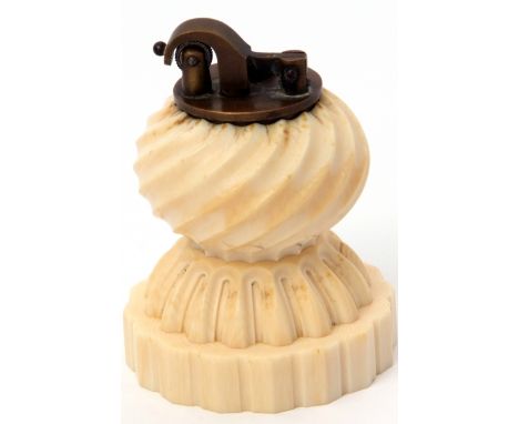 Early 20th century carved ivory table lighter of fluted and waisted circular form with brass lighter inset to the top, the ba