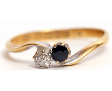 Early 20th century 18ct gold sapphire and diamond cross over ring, set with a circular cut sapphire and a single cut diamond,