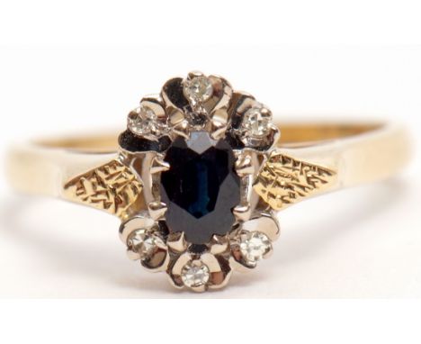 18ct gold sapphire and diamond cluster ring, the dark oval faceted sapphire set between six small diamond surrounds featuring