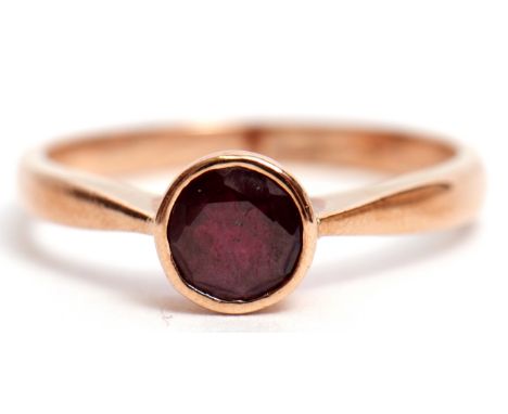 9ct stamped garnet single stone ring, the circular faceted garnet bezel set and raised in a plain polished mount, size O  