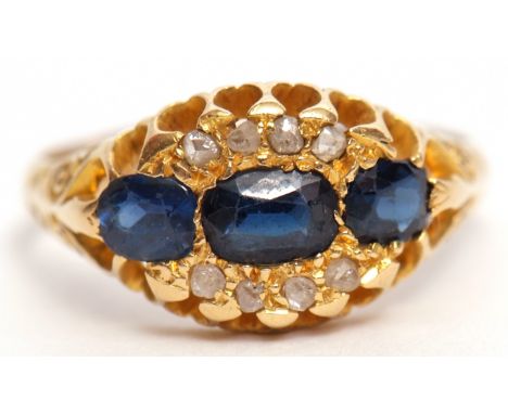 Edwardian 18ct gold sapphire and diamond cluster ring featuring three oval graduated sapphires, interspersed with eight small