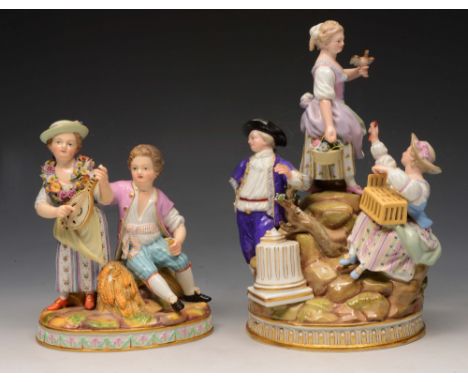 A MEISSEN PORCELAIN GROUP of three figures on a rocky mound, bird and cage, 23cm high and another girl and boy sitting on a w