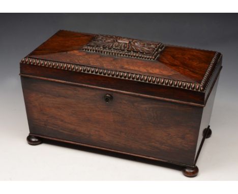 A GEORGE IV ROSEWOOD TEA CADDY, the interior fitted twin compartments enclosed by a hinged rising lid with carved decoration 
