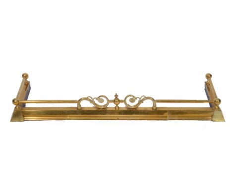 A 19TH CENTURY BRASS FIRE SURROUND with scroll ornament and cylindrical rail, 117cm wide