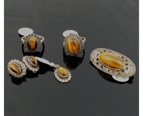 A selection of tiger's eye jewellery comprised of a string of cylindrical beads, an oval brooch set with marcasite with Shipt