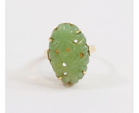 A Chinese jade pierced and carved oval panel, 2cm x 1.8cm, four-claw set in yellow metal metal ring mount stamped '585', 4.5g