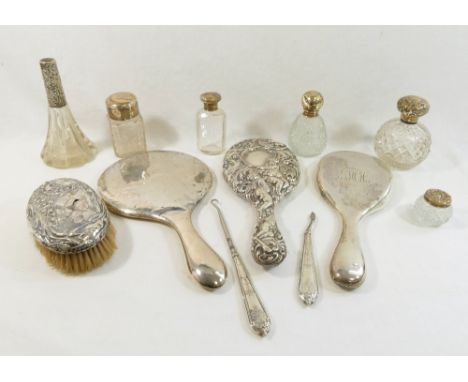 Assorted silver dressing table items comprised of three silver-backed hand mirrors, a silver backed brush, five silver topped