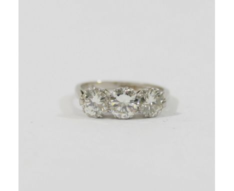 A mid-century platinum and diamond three-stone ring, the round brilliant cut stones combined weight approximately 1.69 carats