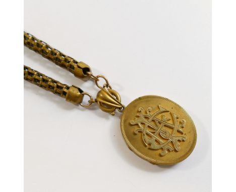 A Victorian oval gold plated locket with intertwined initials set in relief to the front, 3.3cm x 4cm, on a brick link cylind