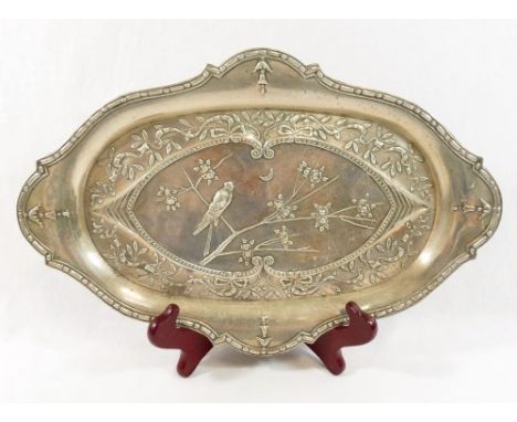 A cartouche-shaped Aesthetic movement silver dressing table tray, Birmingham 1911, embossed with songbird singing to the moon