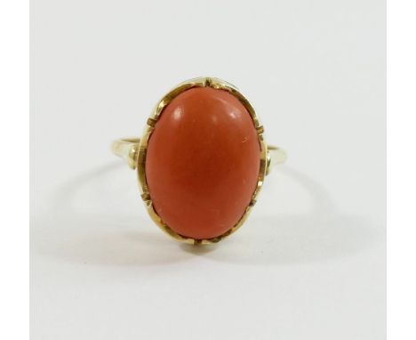 An oval coral cabochon in unmarked yellow metal ring mount, finger size K, 3.7g gross CONDITION REPORTS & PAYMENT DETAILS IMP