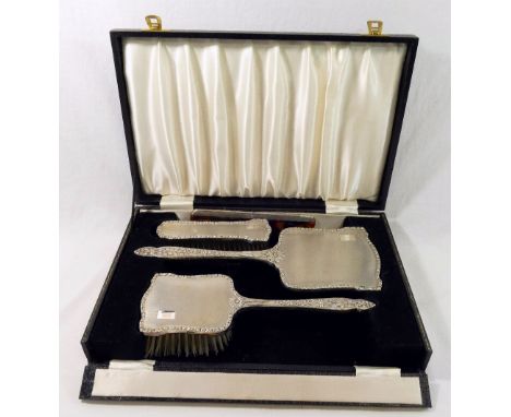 A silver backed dressing table set, comprised of a long handled hair brush, a smaller hair brush, a hand mirror and a comb, B