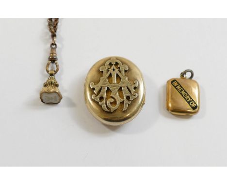 A large Victorian gold plated oval locket brooch with raised intertwined initials to the front, 3.6cm x 3cm, a small Victoria