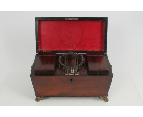 Late Regency mahogany and ebony strung tea caddy of sarcophagus form, with flanking lion mask drop-handles, the interior with