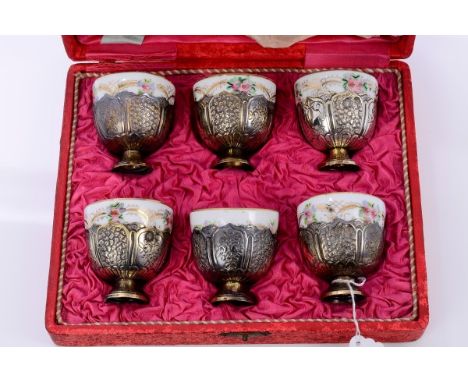 Set of six Turkish silver and parcel gilt coffee cups with panels of chased floral decoration, on pedestal bases with Russian