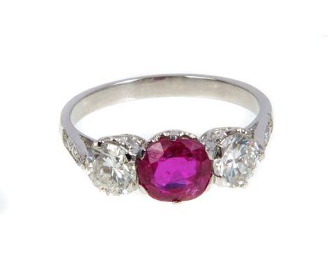 Ruby and diamond three stone ring with an oval mixed cut ruby estimated to weigh approximately 1.20 carats, flanked by a bril