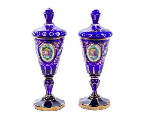 Pair of 19th century Bohemian overlaid glass vases and covers, each cover with facetted knop finial, the vase of goblet form,