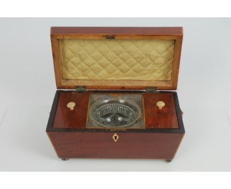 Late Regency mahogany and boxwood strung tea caddy of sarcophagus form, with flanking lion mask ring handles, the interior wi