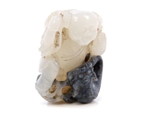 Good 19th century Chinese two-tone jade group, carved with a figure carrying baskets, entwined with a mythical beast, the fig
