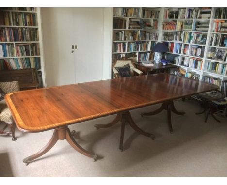 Fine quality Regency-style rosewood and satinwood crossbanded triple pedestal dining table of prodigious size, the rounded re