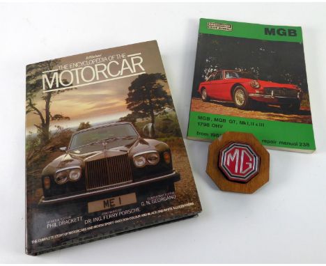 M.G. ENAMELLED MOTORCAR BADGE, octagonal, for bumper mounting, now on a wooden back board; M.G.B. REPAIR MANUAL No. 238 and t