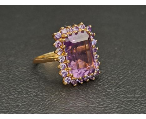 AMETHYST CLUSTER DRESS RINGthe central step cut amethyst measuring approximately 14mm x 10mm x 6.5mm, in surround of twenty-t