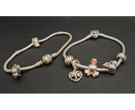 TWO PANDORA MOMENTS SILVER CHARM BRACELETSone with three charms and two clips and the other with two charms, the charms inclu