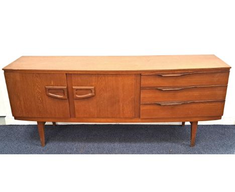 RETRO 1960s TEAK BOW FRONT SIDEBOARDwith a central drop front flap revealing a drinks cabinet, flanked by a cupboard and thre