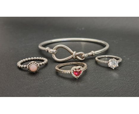 SELECTION OF PANDORA SILVER JEWELLERYcomprising an Infinity knot bangle, and three rings - Elevated Red Heart, October Births