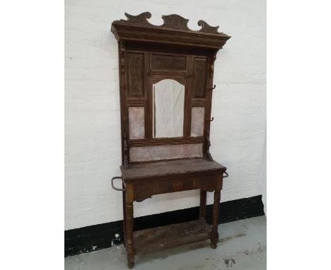 EDWARDIAN OAK HALL STANDwith a shaped carved top rail above carved panels with a central arched bevelled mirror and marble pa