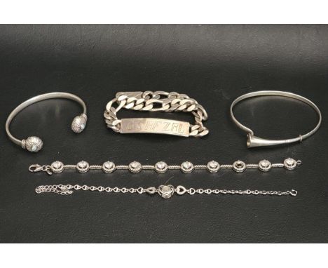 SELECTION OF FIVE SILVER BANGLES AND BRACELETScomprising a bangle with trumpet shaped flower detail, with Platinum Jubilee ma