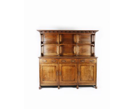 A large Morris &amp; Co fumed oak sideboard/buffet, three cupboards under two tier shelf mantel with simple mouldings and pan