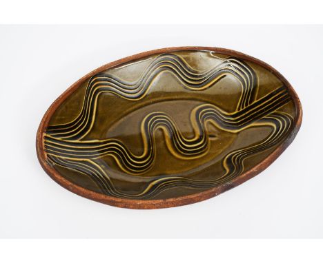 Michael Cardew (1901-1983), attributed a Wenford Bridge pottery elliptical platter, comb decorated with a meandering river mo