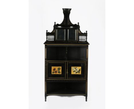 An Aesthetic Movement ebonised wood corner cabinet, triangular section, two shelves flanking central twin door cabinet with p