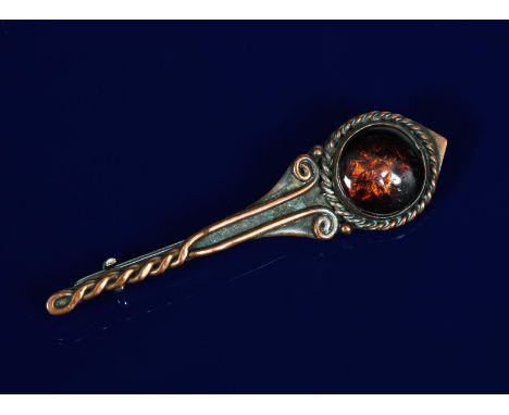 A Celtic Revival copper and enamel bar brooch attributed to the Bournville School,  simple wirework decoration with deep red 