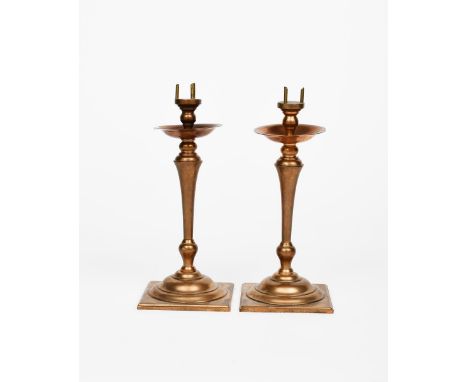A pair of W.A.S. Benson copper and brass candlesticks, model no., the square base supporting domed base, knopped stem and fla