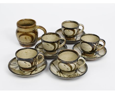 Rupert Spira (born 1960) five stoneware cups and saucers, painted in tenmoku on an ash glaze, and a tankard impressed seal ma