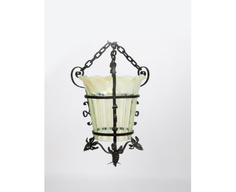 A patinated metal and vaseline glass lantern,  modelled with flower terminals,  the flaring vaseline glass shade with fluted 
