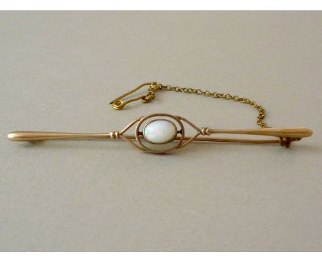 An Edwardian opal bar brooch, in an openwork arrangement with central oval cabochon stone bezel-set within an annulus, the la