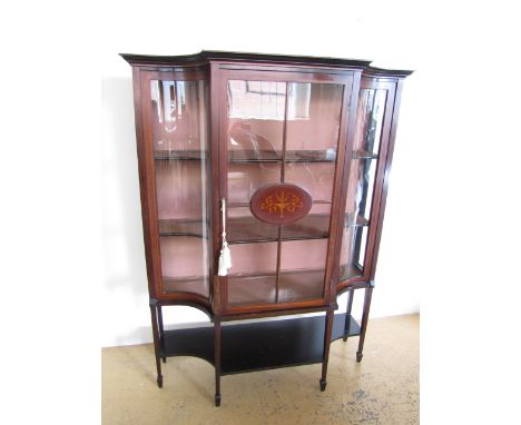 An Edwardian Sheraton revival inlaid mahogany display cabinet, having a moulded cornice with dentil-banded frieze above an as